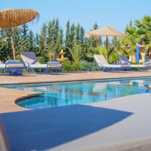 piscina con sedie e ombrellone di Villa Coup De Cœur a Marrakech