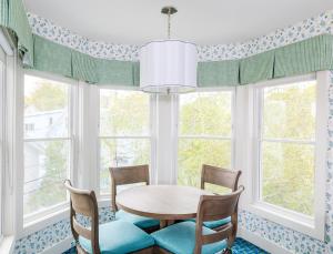 a dining room with a table and chairs and windows at Lake View Hotel in Mackinac Island