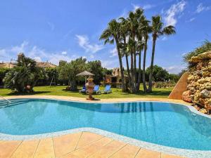 una piscina en un patio con palmeras en Belvilla by OYO Gamundi, en Muro 32 fotos más
