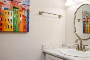 a bathroom with a sink and a painting on the wall at Sunset Blvd by Pristine Properties Vacation Rentals in Saint Joe Beach