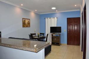 sala de estar con paredes azules, TV y mesa en Apartamentos Alta Vista en David