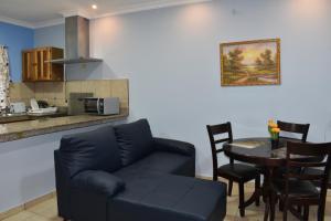 sala de estar con sofá y mesa con sillas en Apartamentos Alta Vista en David