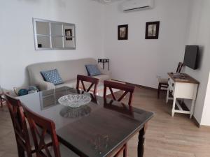 een woonkamer met een tafel en een bank bij Casa dúplex en el centro in Carmona
