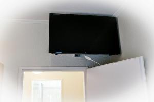 - une télévision à écran plat sur un mur au-dessus d'une porte dans l'établissement Strandhochhaus SG04, à Cuxhaven