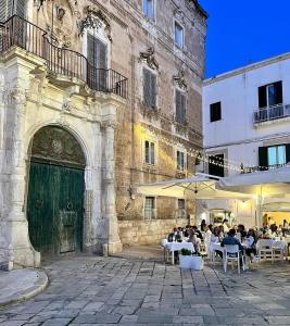 a group of people sitting at tables in front of a building at Dimora Barbacana in Monopoli