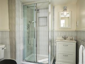 a bathroom with a glass shower and a sink at The Old Coach House in Henley on Thames +24 photos