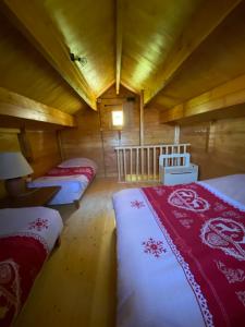 a bedroom with two beds in a wooden cabin at Chalet de La Peyramont in Lanarce