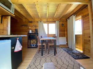 - une cuisine avec une table et des chaises dans une cabine dans l'établissement Chalet de La Peyramont, à Lanarce
