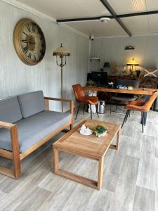 a living room with a couch and a table and a clock at Malta Bodrum in Bodrum City