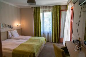 a hotel room with a bed and a window at Cvetni Konaci in Vrnjačka Banja