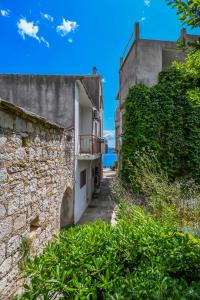 an alley between two buildings with the ocean in the background at Apartment Tonci in Igrane