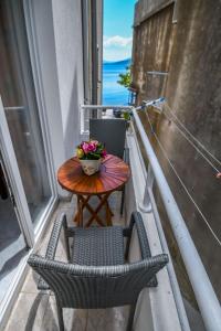 a table and chairs on a balcony with a table and flowers at Apartment Tonci in Igrane
