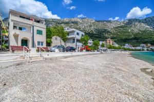 a beach in a town with buildings and the water at Apartment Tonci in Igrane +6 photos