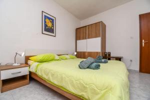 a bedroom with a large bed with yellow sheets at Apartment Tonci in Igrane