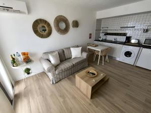 プエルト・デル・カルメンにあるApartamentos La Floridaのソファとテーブルのあるリビングルーム +2枚の写真