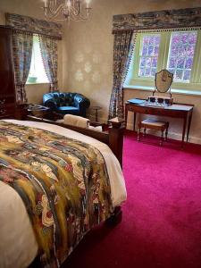 a bedroom with a bed and a desk and a chair at Braithwaite Hall Bed & Breakfast in Middleham