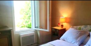 ein Schlafzimmer mit einem Bett neben einem Fenster in der Unterkunft Lavignegîte in Bugeat
