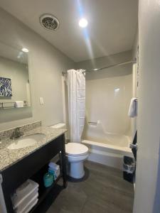 a bathroom with a toilet and a sink and a tub at Indigo in Myrtle Beach