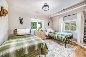 ein Schlafzimmer mit zwei Betten und einem Fenster in der Unterkunft Hillside Cottaga- Private pond, hot tub, game room, by ONP in Port Angeles