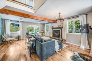 ein Wohnzimmer mit einer blauen Couch und einem Kamin in der Unterkunft Hillside Cottaga- Private pond, hot tub, game room, by ONP in Port Angeles