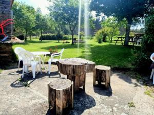 einen Tisch und Stühle, einen Tisch und einige Holzscheite in der Unterkunft Casa vacacional galicia in A Coruña
