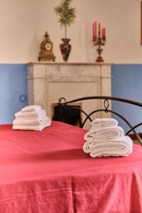 dos pilas de toallas sentadas sobre una mesa roja en Palazzo Scarciglia en Minervino di Lecce