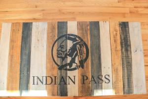 um sinal de passe índio numa parede de madeira em Attitude Adjustment by Pristine Properties Vacation Rentals em Indian Pass