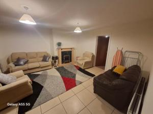 a living room with two couches and a fireplace at Gala House in Lurgan
