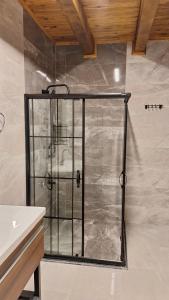 a shower with a glass door in a bathroom at Hemşin Ata Konağım in Çamlıhemşin