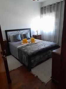 Un dormitorio con una cama con dos velas amarillas encima. en AlojamentoGodimDouro, en Peso da Régua 2 fotos más