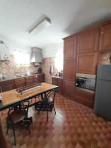 Una cocina con gabinetes de madera y una mesa con sillas. en AlojamentoGodimDouro, en Peso da Régua
