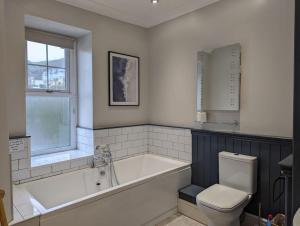 a bathroom with a bath tub and a toilet at Pencartref Apartment - 4 Bedrooms, 3 Bathrooms, Sleeps 7-8 in Aberdyfi +25 photos