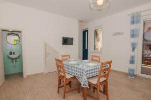 una sala da pranzo con un tavolo e quattro sedie di Casa Lillì a Ischia