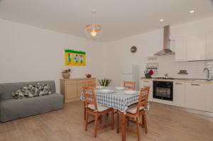 una cucina e un soggiorno con tavolo e sedie di Casa Lillì a Ischia