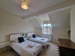 a bedroom with two beds and a desk and a window at Contemporary apartment in Cromer in Cromer