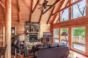 een woonkamer met een bank en een open haard bij Pinnacle View Lodge by Stony Brook Cabins in Gatlinburg +27 foto's