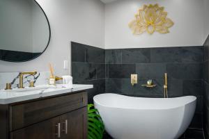 a bathroom with a tub and a sink and a mirror at 5-Star Luxury Sauna-Spa Retreat Near Volcano Nat'l in Volcano