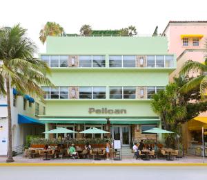 un edificio con gente sentada en mesas delante de él en Pelican Hotel, en Miami Beach