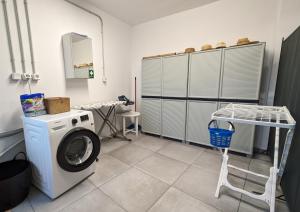 uma lavandaria com uma máquina de lavar roupa e uma mesa em Sabaton Apartment em Leonidio