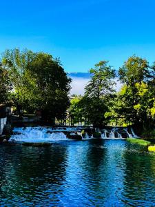 a waterfall in the middle of a pond at Apartment Bijela ladja in Bihać