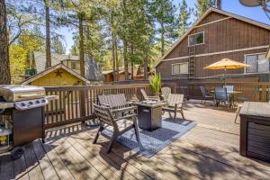 a wooden deck with a grill and tables and chairs at 5 Mi to Big Bear Lake Pet-Friendly Gem Near Hikes in Sugarloaf