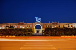 a building with a sign on top of it at night at Hotel Thàlas Club in Torre dell'Orso