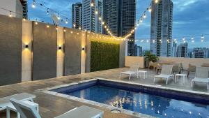 un patio en la azotea con piscina, mesas y sillas en Victoria Hotel and Suites Panama en Panamá