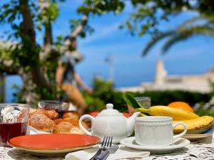 ein Tisch mit einem Teller Essen und einer Tasse Tee in der Unterkunft Casa Zagami in Malfa