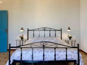 a bed in a bedroom with two lamps on the wall at Casa Zagami in Malfa