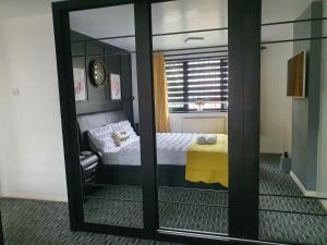 een spiegel in een kamer met een bed en een raam bij Professional Stay Doctors Nurses Trades in Luton