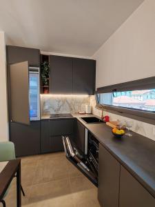 a kitchen with black cabinets and a counter top at Casa Maribella Cattolica in Cattolica