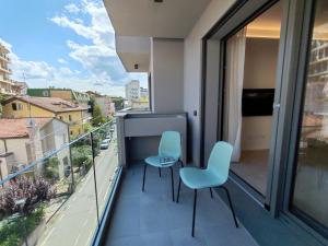 a balcony with two chairs and a view of a city at Casa Maribella Cattolica in Cattolica
