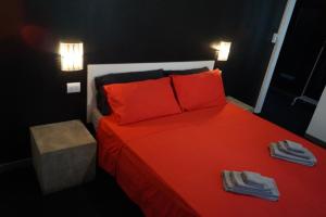 sypialnia z czerwonym łóżkiem i czerwonymi poduszkami w obiekcie Stupido Hotel Rimini w Rimini