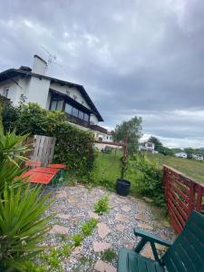 une maison avec une clôture rouge et deux bancs dans l'établissement Terre et mer, à Urrugne